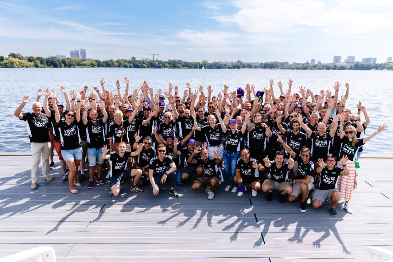 Group picture of 1KOMMA5° in front of water