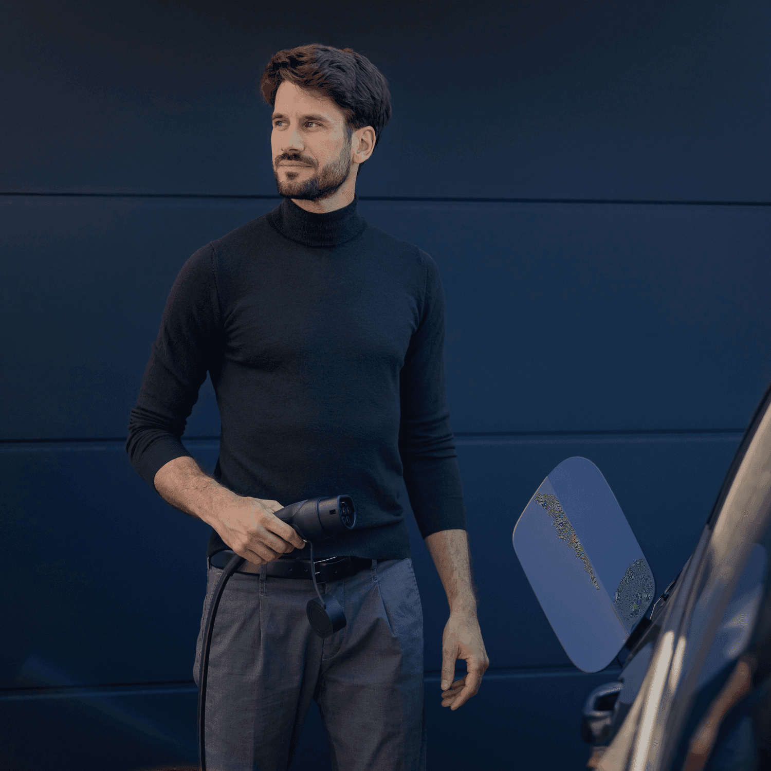 Mann lädt sein Elektoauto mit der 1KOMMA5° Wallbox