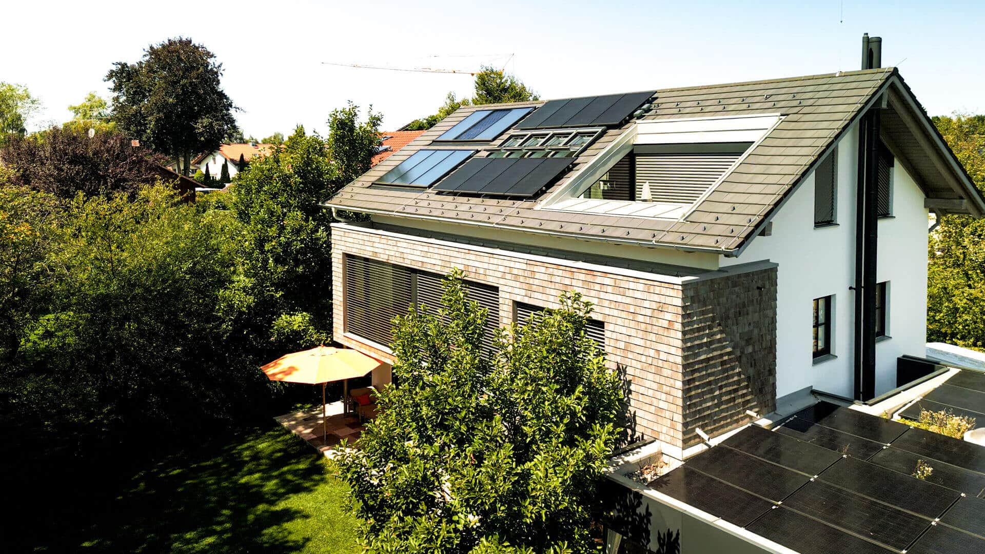Einfamilienhaus mit effizienter Solaranlage auf dem Dach und Garten.