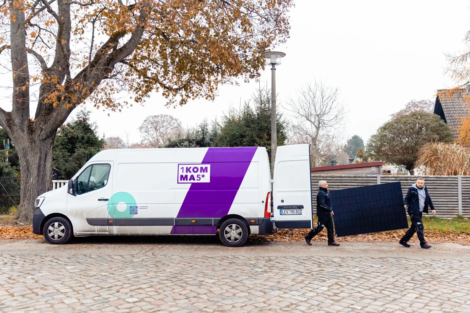 Furgoneta, trabajadores y placa solar de 1KOMMA5