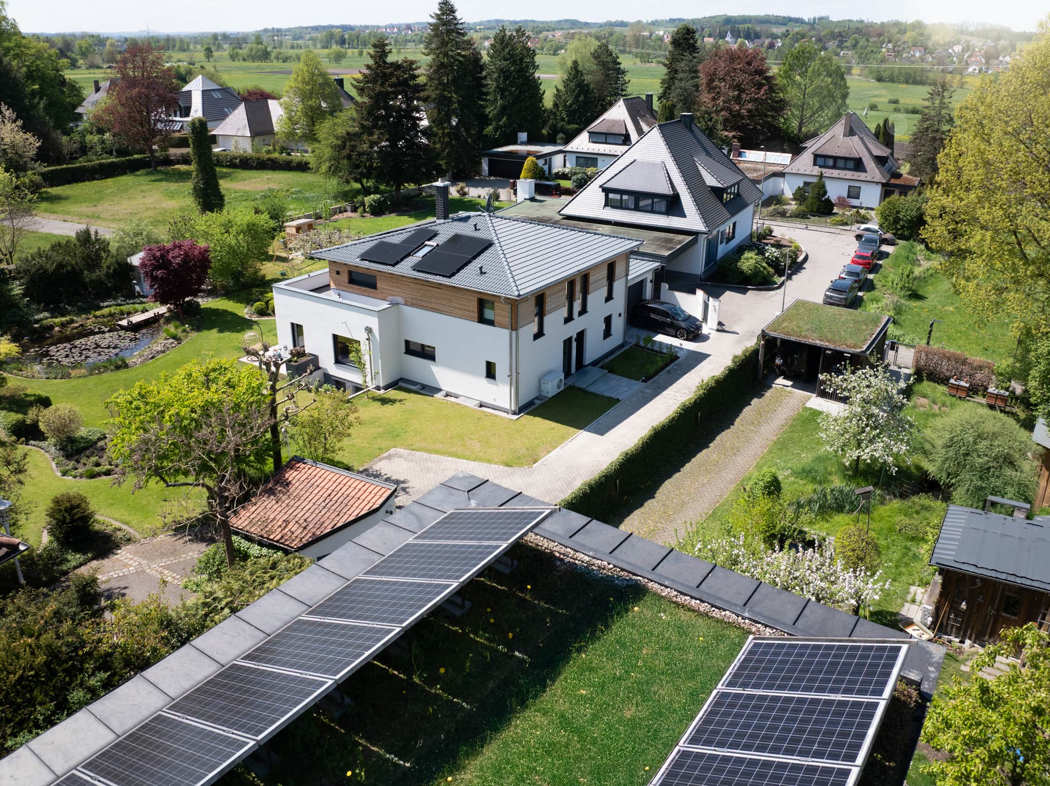Solarmodule auf dem Dach eines modernen Einfamilienhauses bei Sonnenschein.