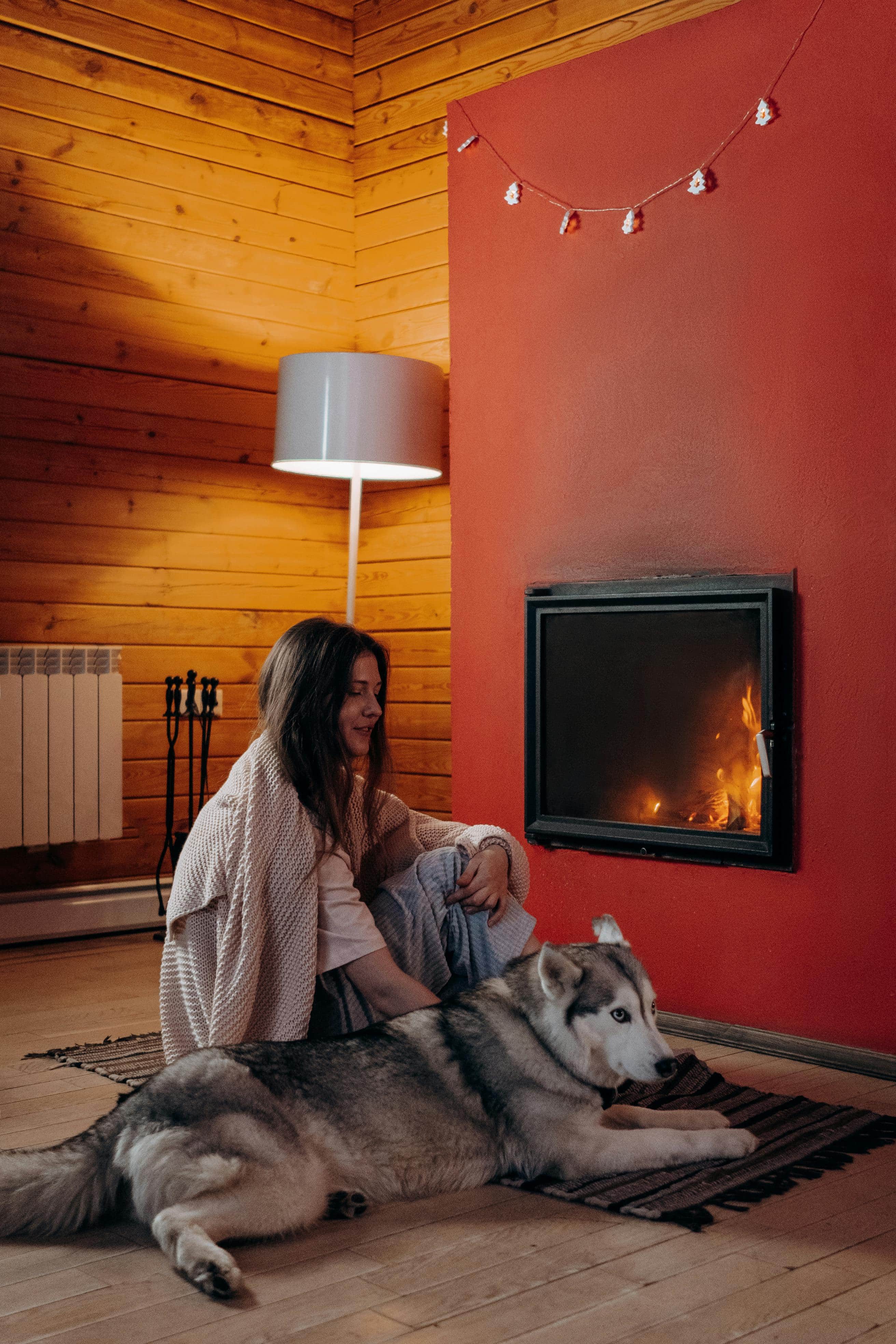 woman petting her dog near fireplace