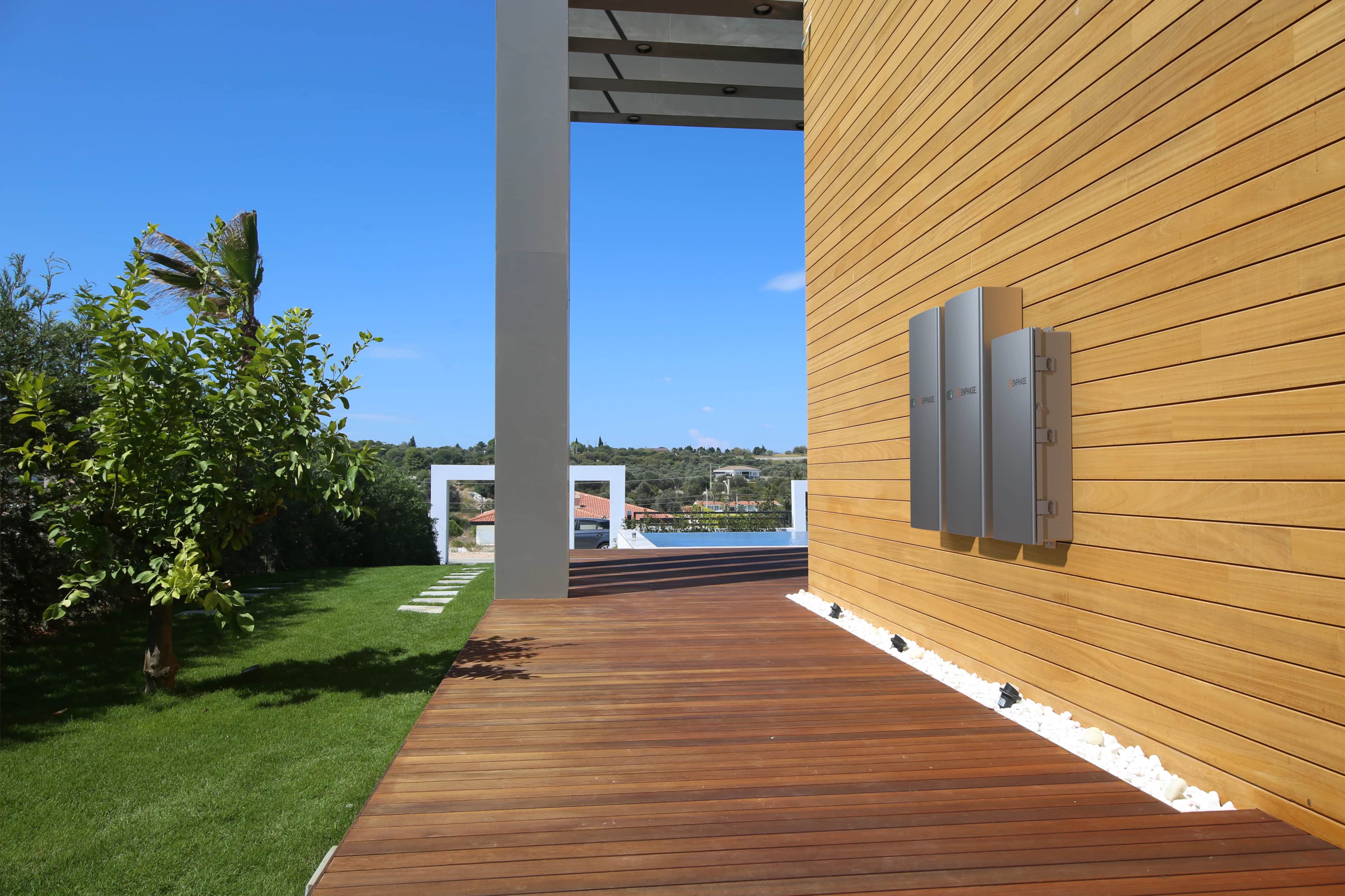 Enphase IQ Battery mounted on the outside wall of a modern house