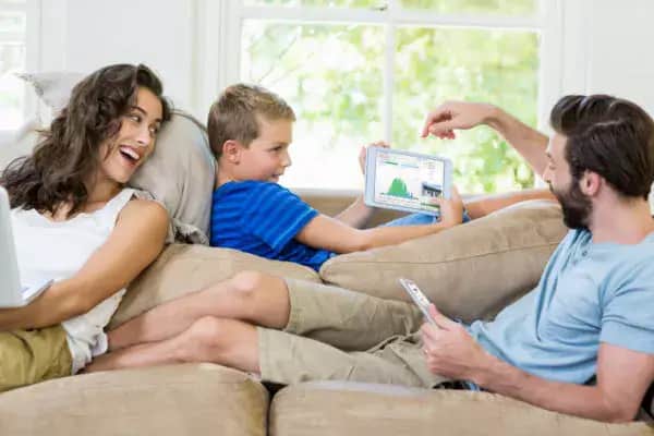 happy family in the living room holding gadgets