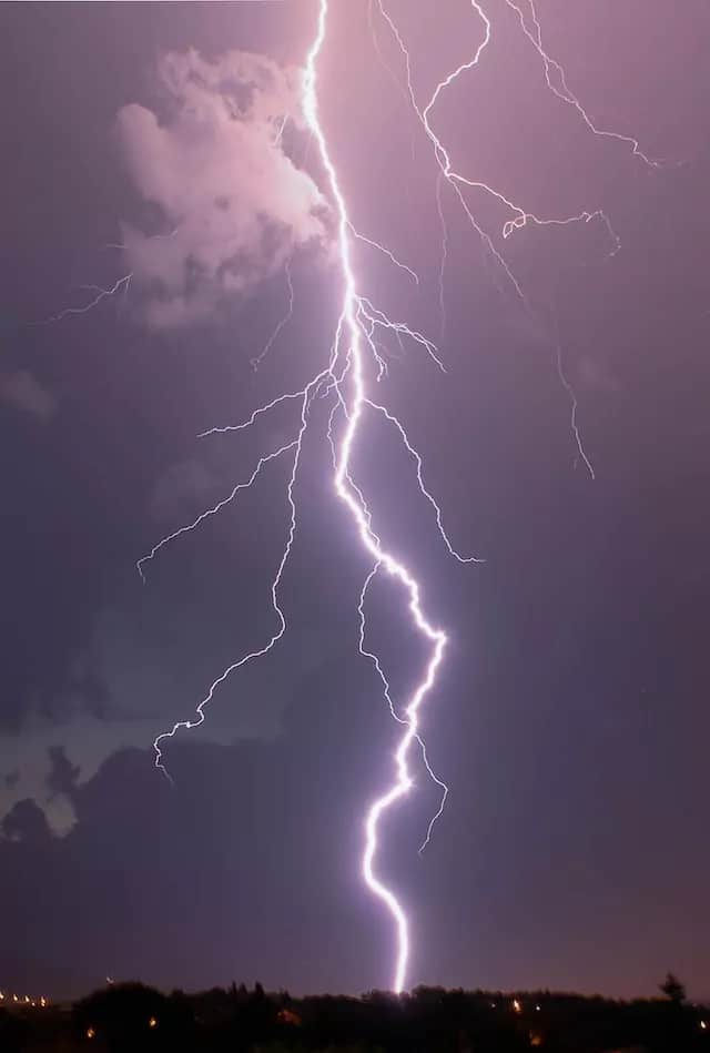 a bright bolt of lightning striking against a dark, cloudy sky