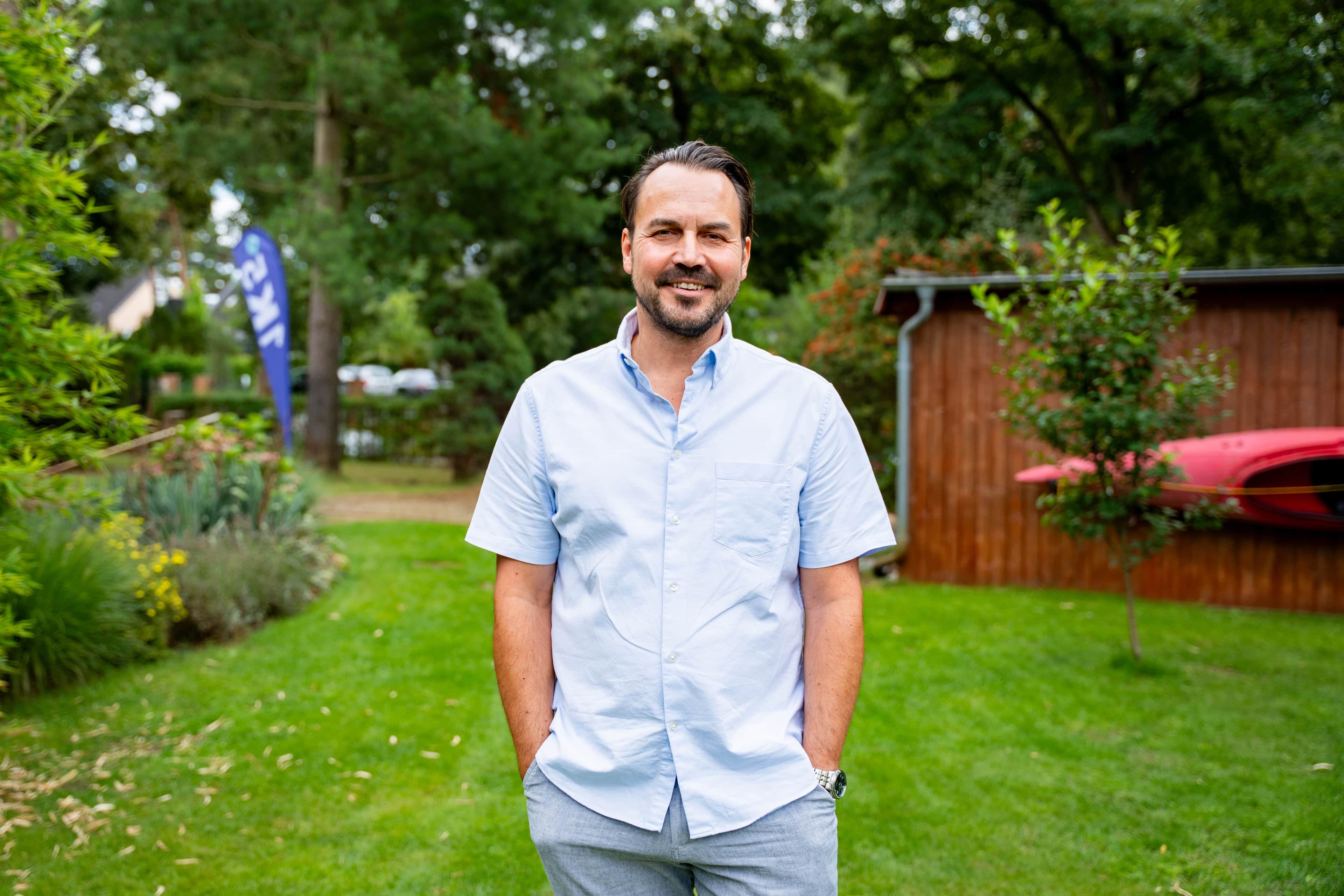 Mann steht in einem Garten