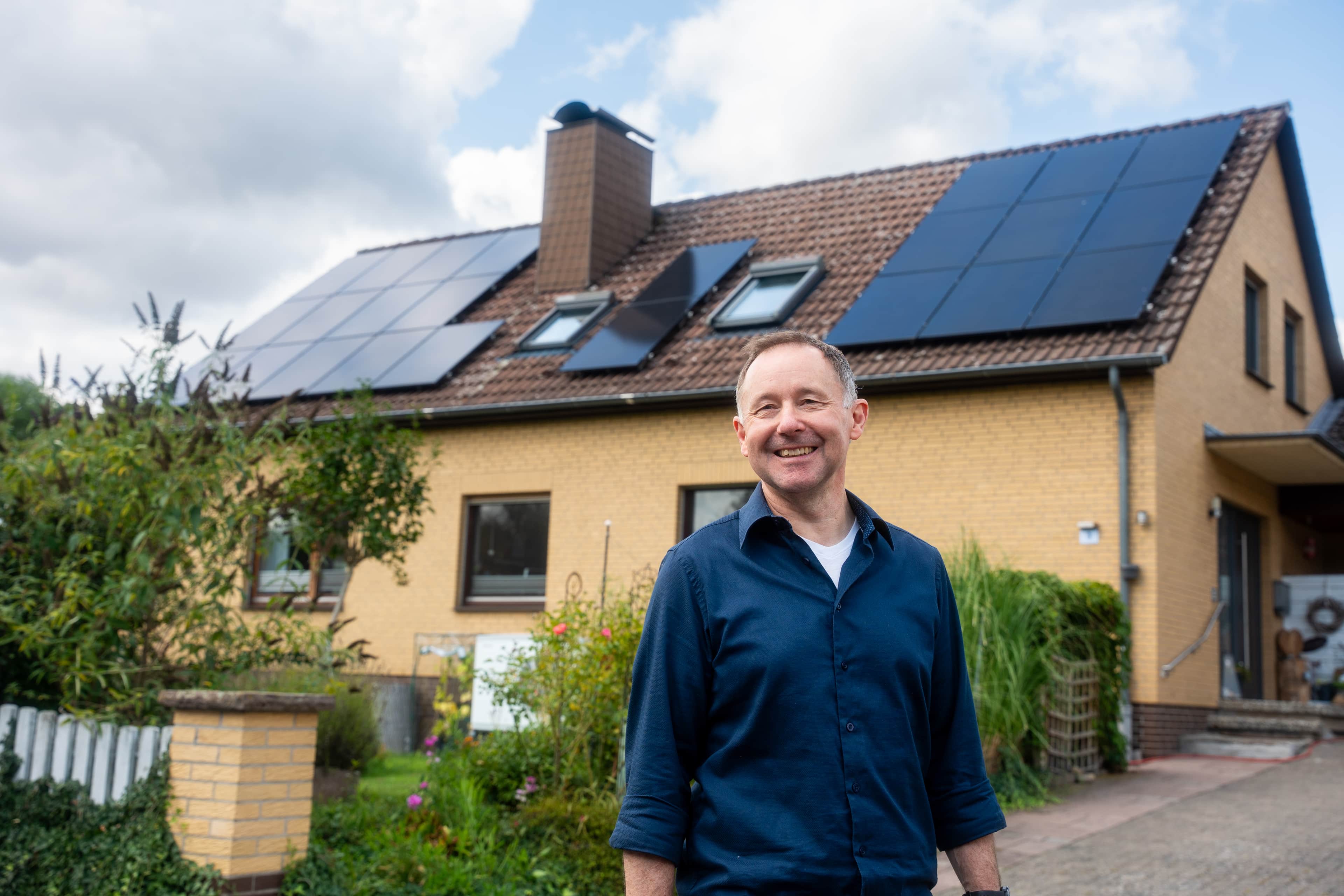 Carsten Klinge vor seinem Haus mit PV-Anlage auf dem Dach