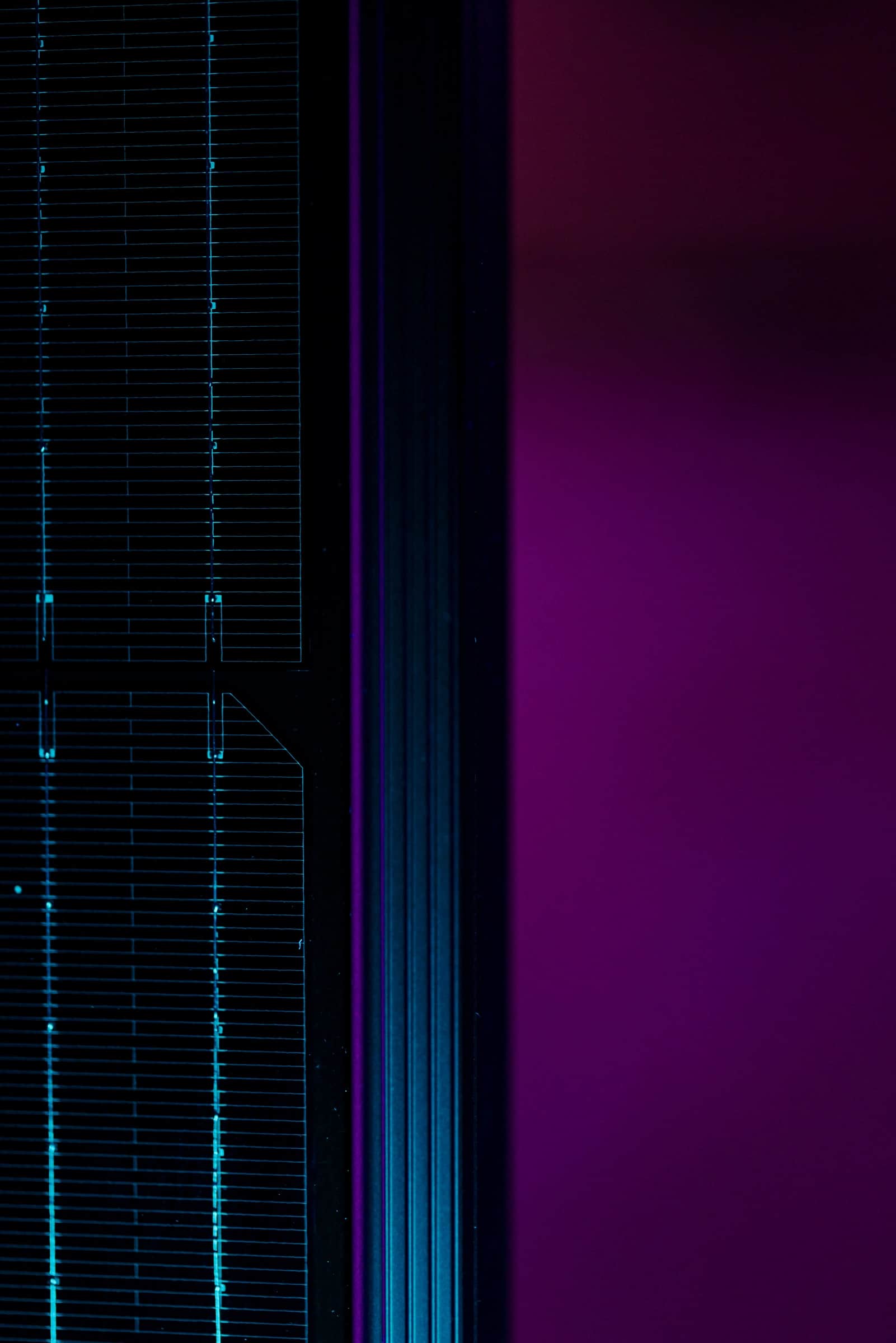 Lähikuva aurinkopaneelista, jonka vasemmalla puolella on ruutukuvio ja oikealla puolella eloisa violetti tausta.