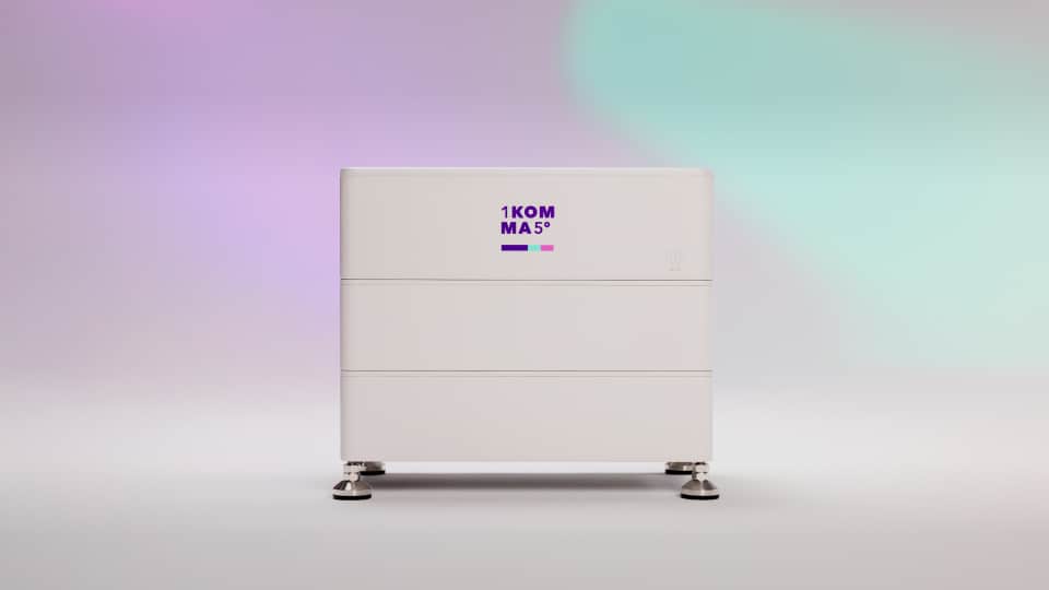 Tyylikäs, moderni, valkoinen suorakaiteen muotoinen aurinkoenergian akku, jossa on "KOMMAS"-logo, liukuvärisen violetin ja turkoosin sävyisessä taustassa.