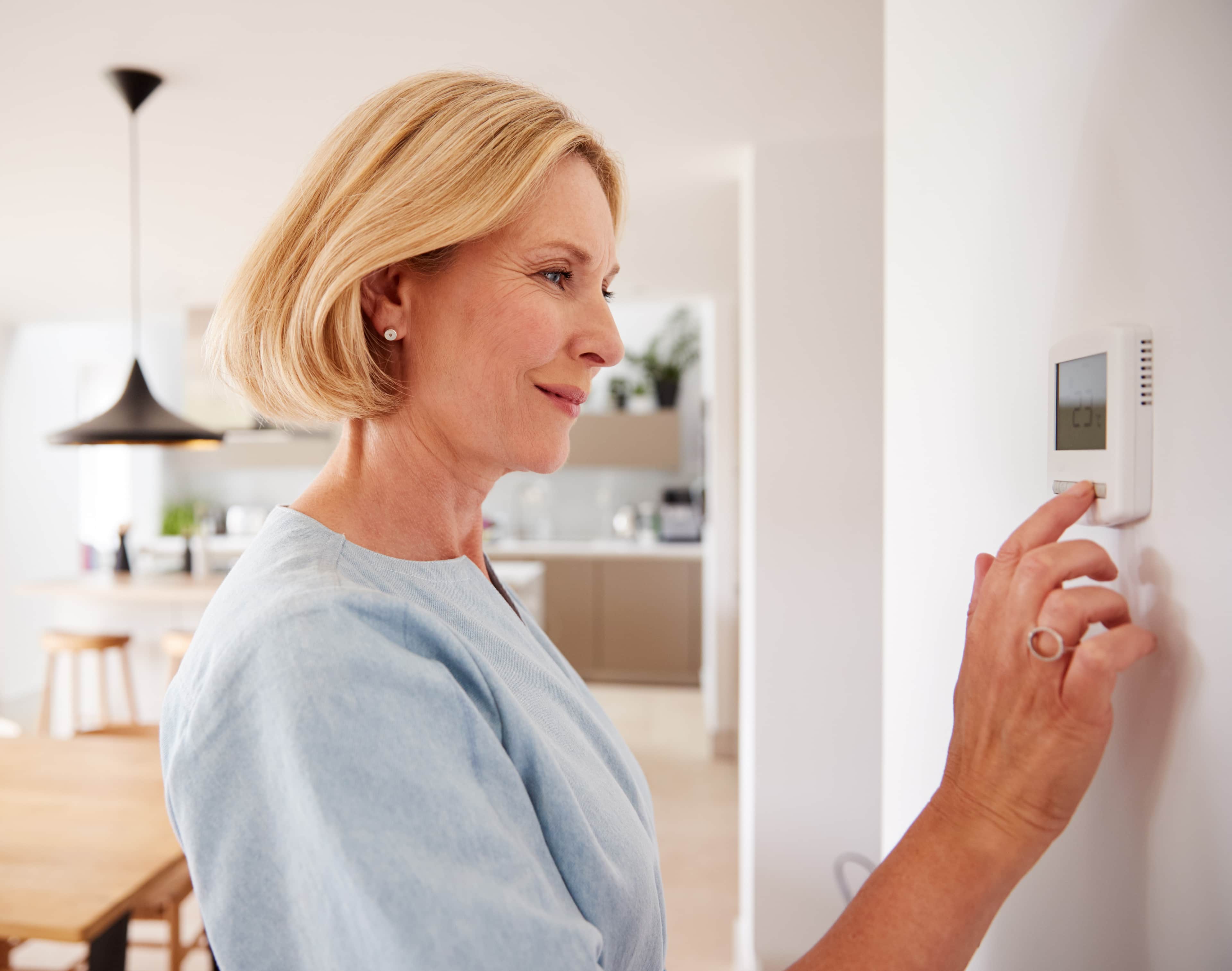 Frau bedient Klimaanlage