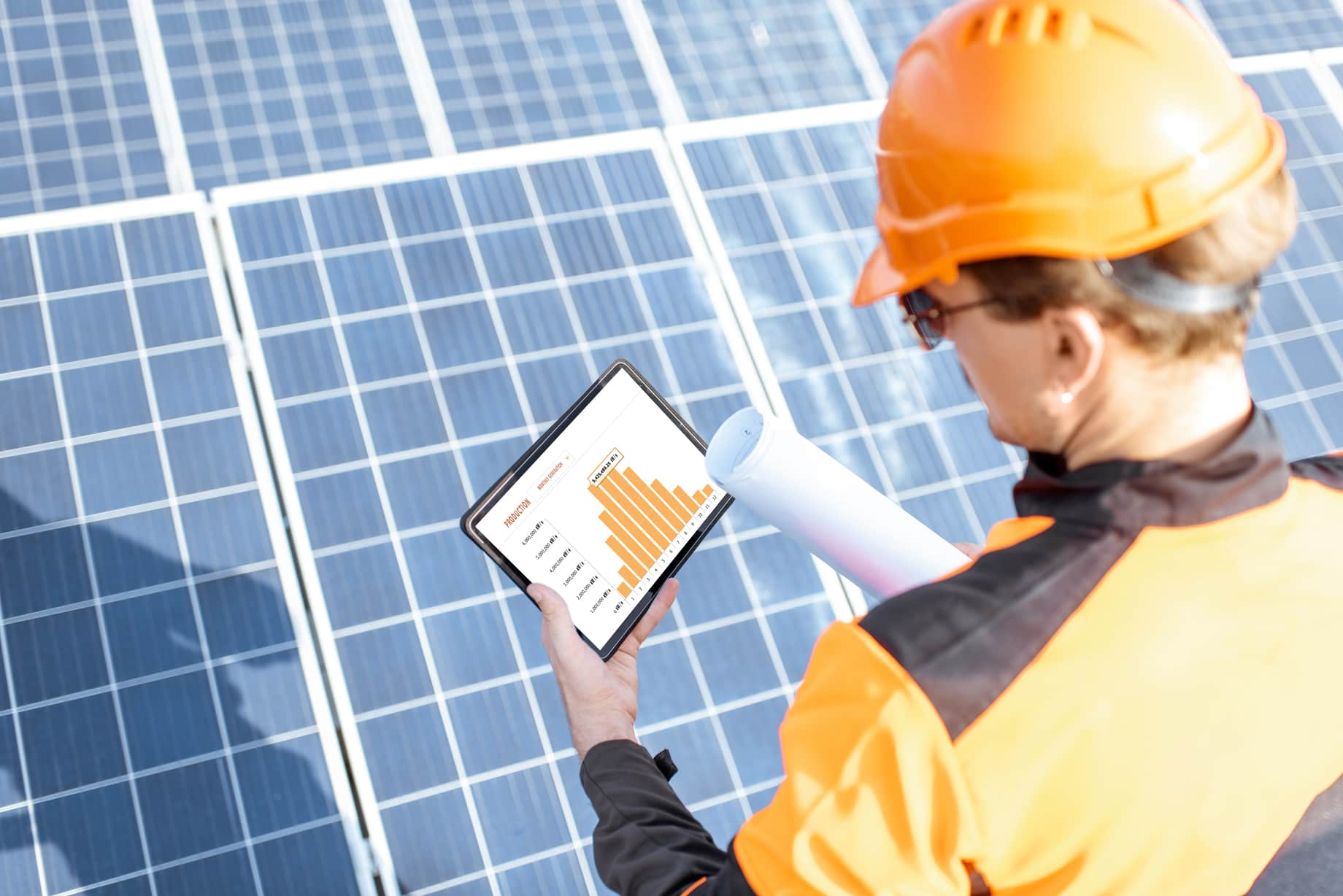 man with an ipad examining solar panel production