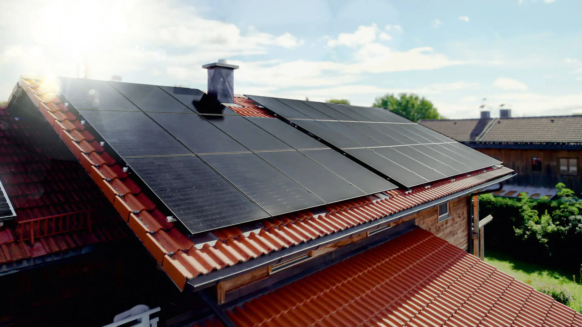 Placas solares 1KOMMA5° perfectamente instaladas en el tejado de tejas de una vivienda
