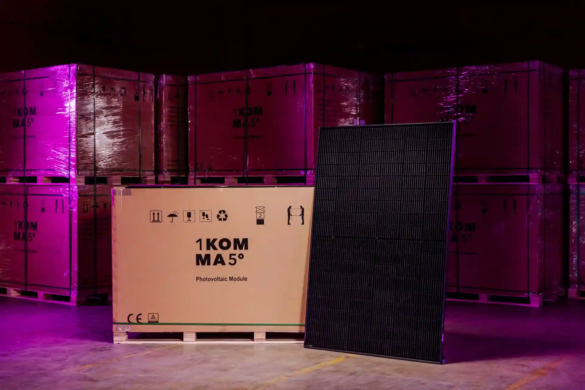 Panel solar 'Full Black' de 1KOMMA5° de alta eficiencia y diseño elegante, mostrado junto a su embalaje.