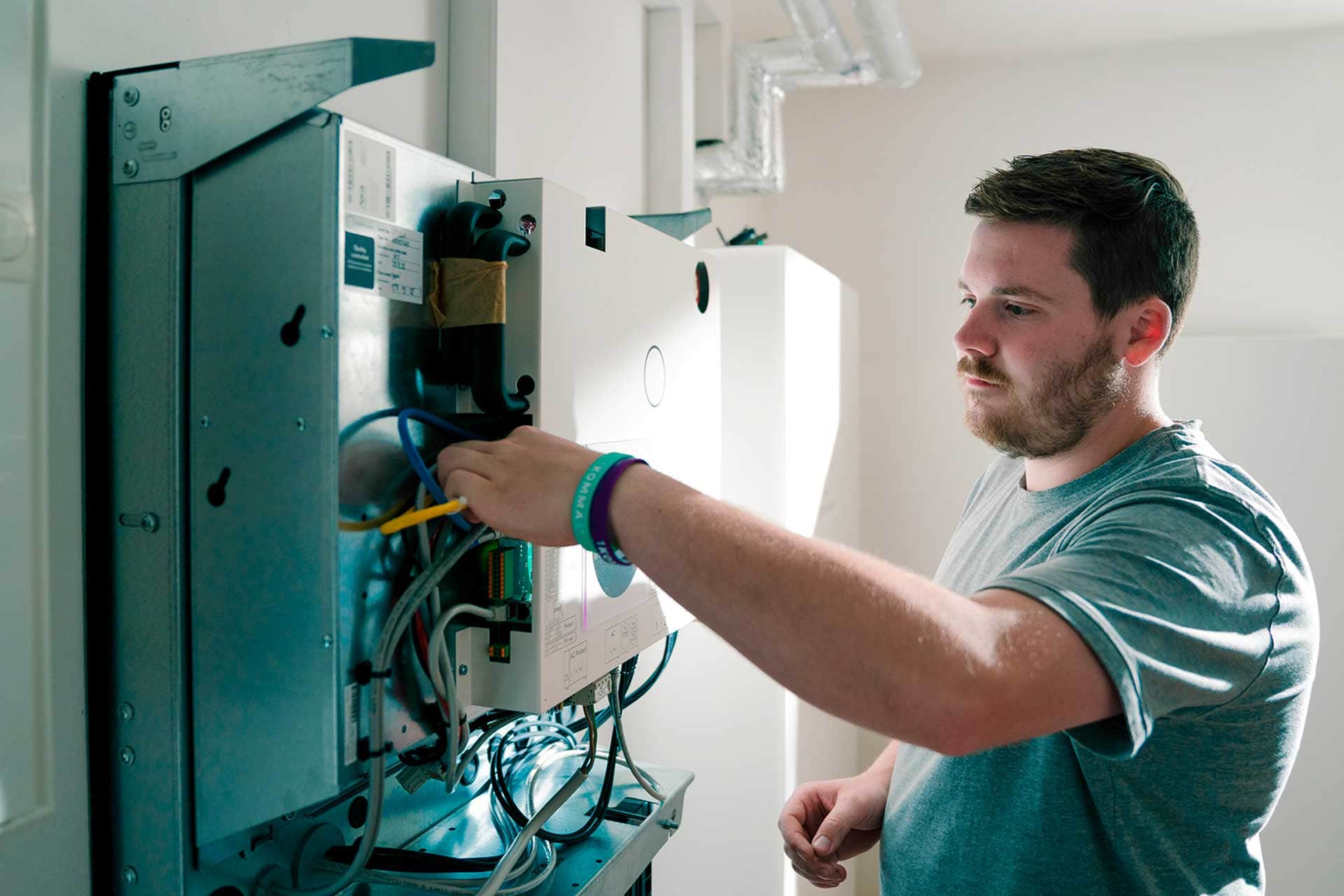 A 1KOMMA5° technician performing maintenance on an electrical panel