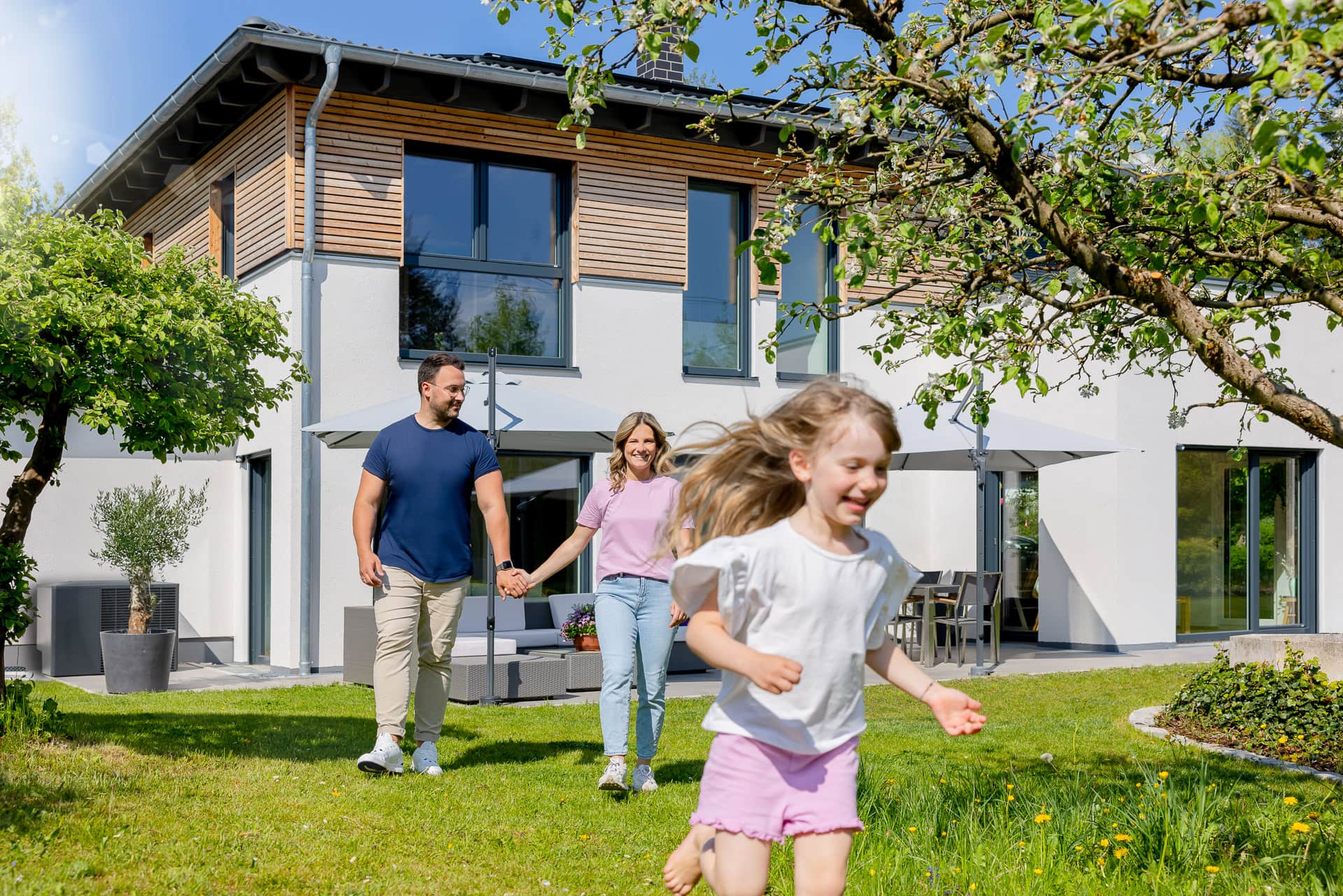 Familie vor Haus mit PV-Anlage