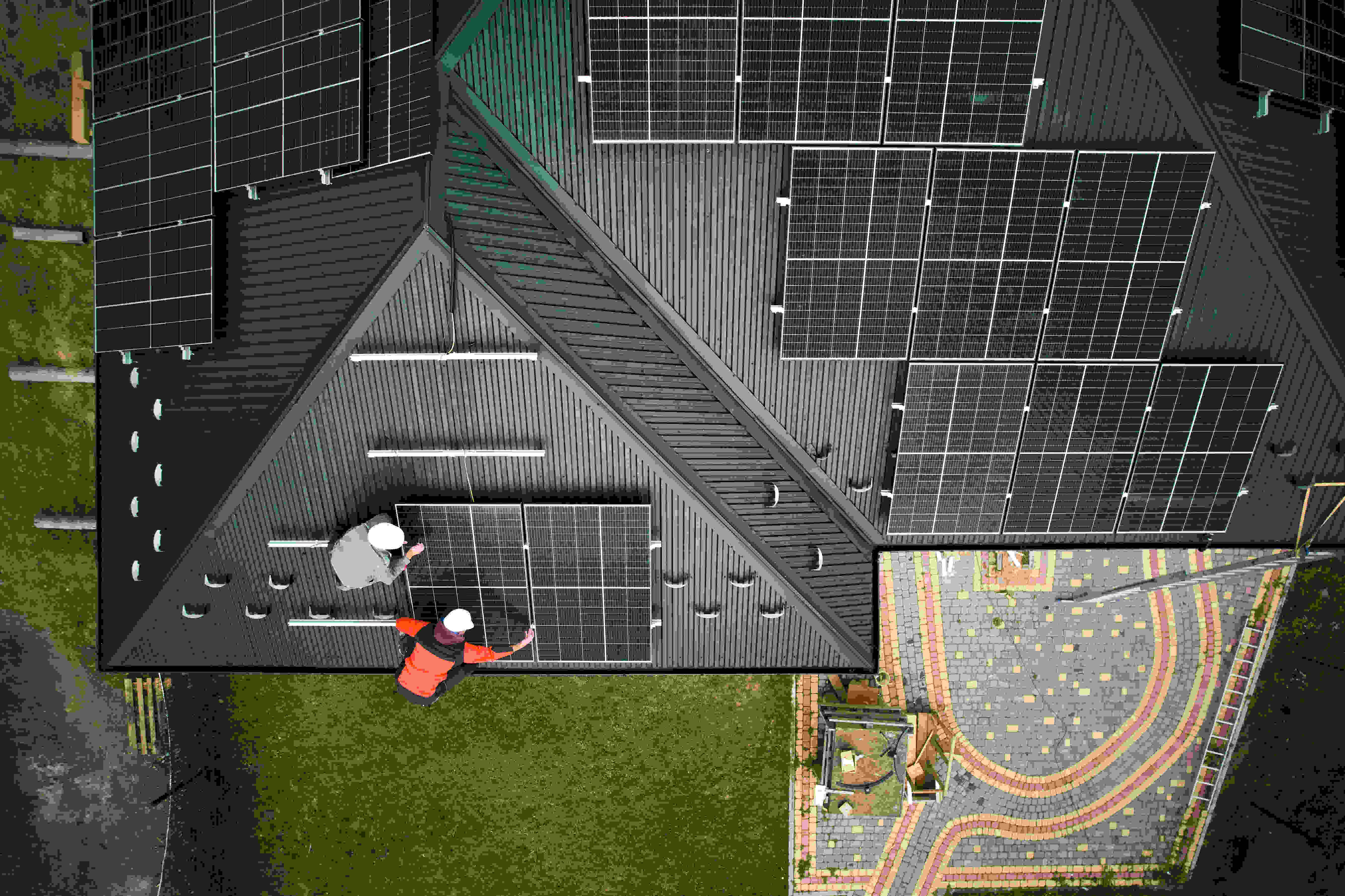 house with solar panels on roof with two workers