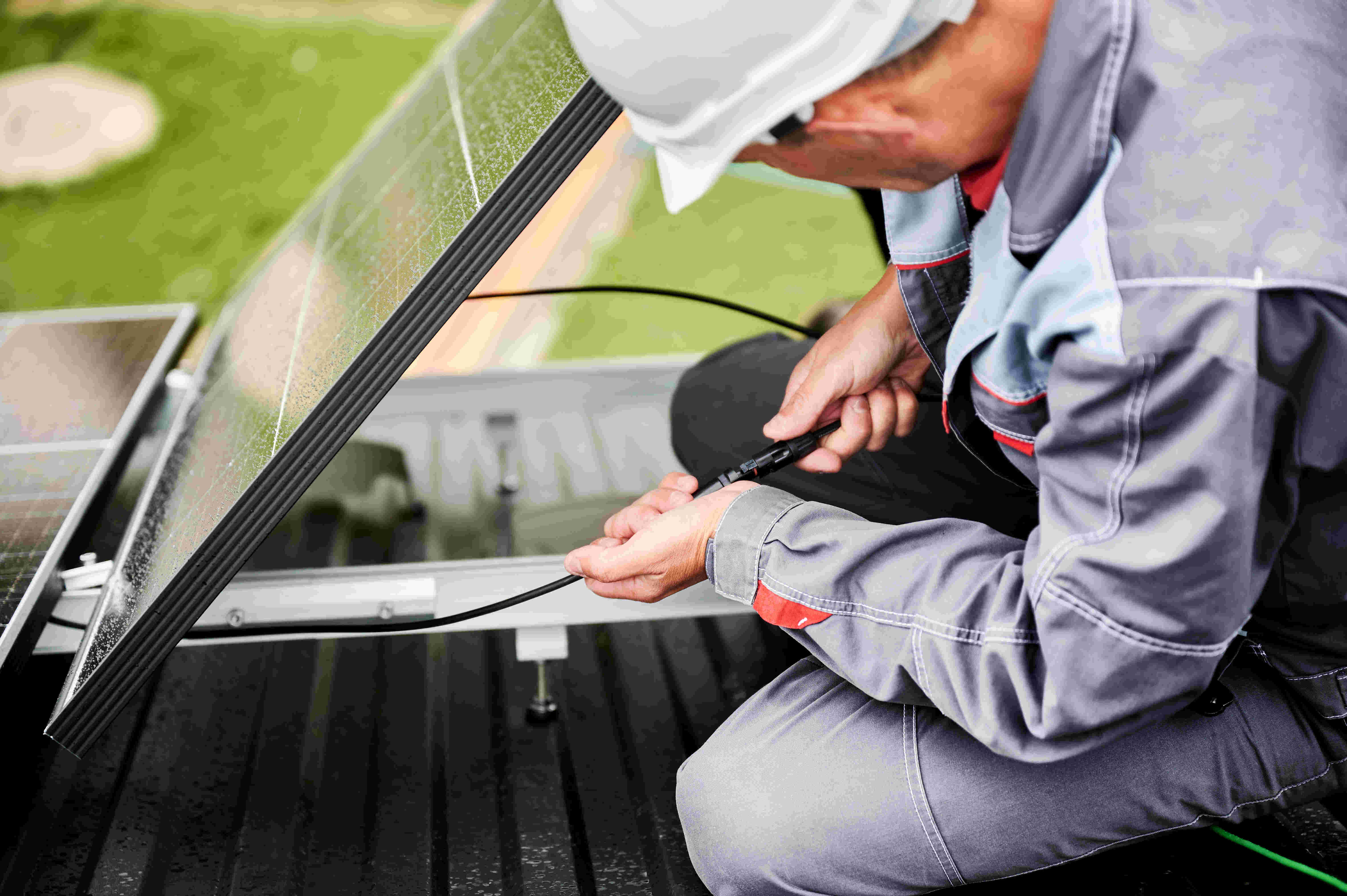 installer working on cables underneath a solar panel