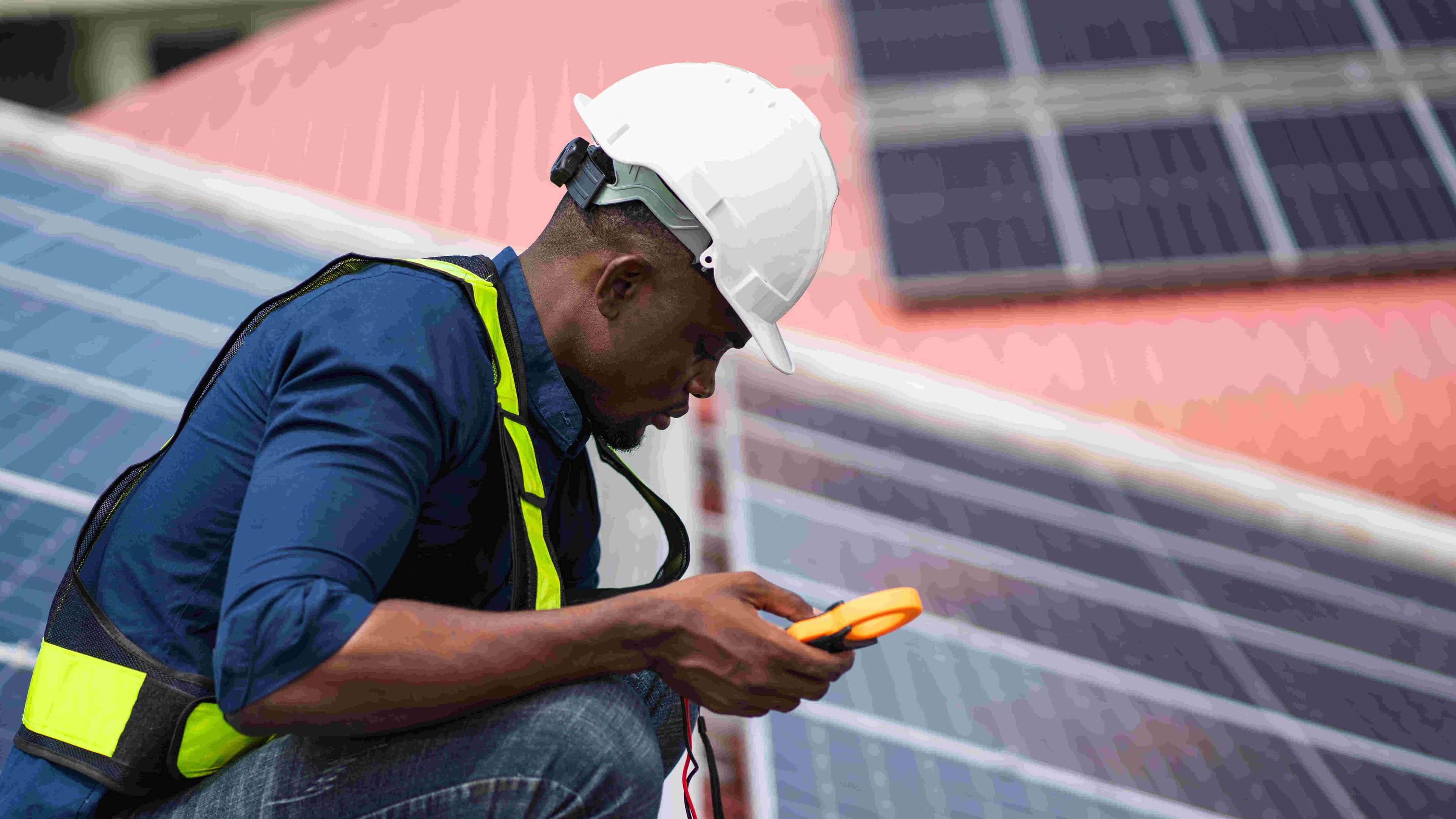 service engineer holding a tool checking on solar panels