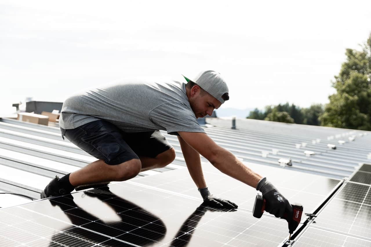 Solcellsmontör installerar solpanel från 1KOMMA5° på hustak