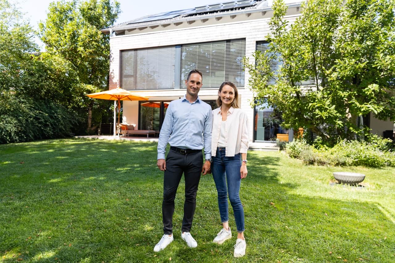 Par poserar framför sin villabostad med solceller från 1KOMMA5°