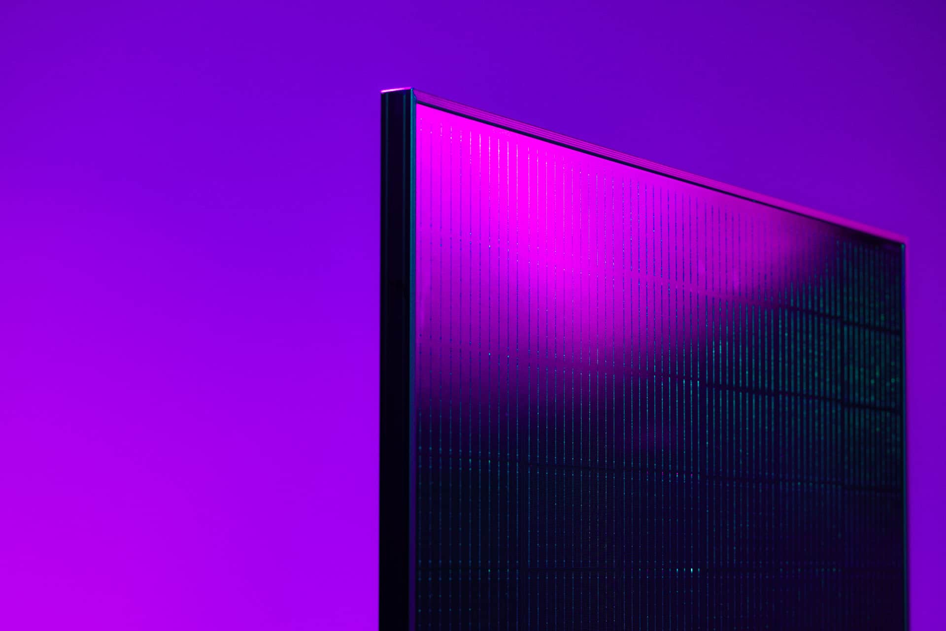 Lähikuva tyylikkäästä, modernista aurinkopaneelista eloisan violetin taustan edessä.