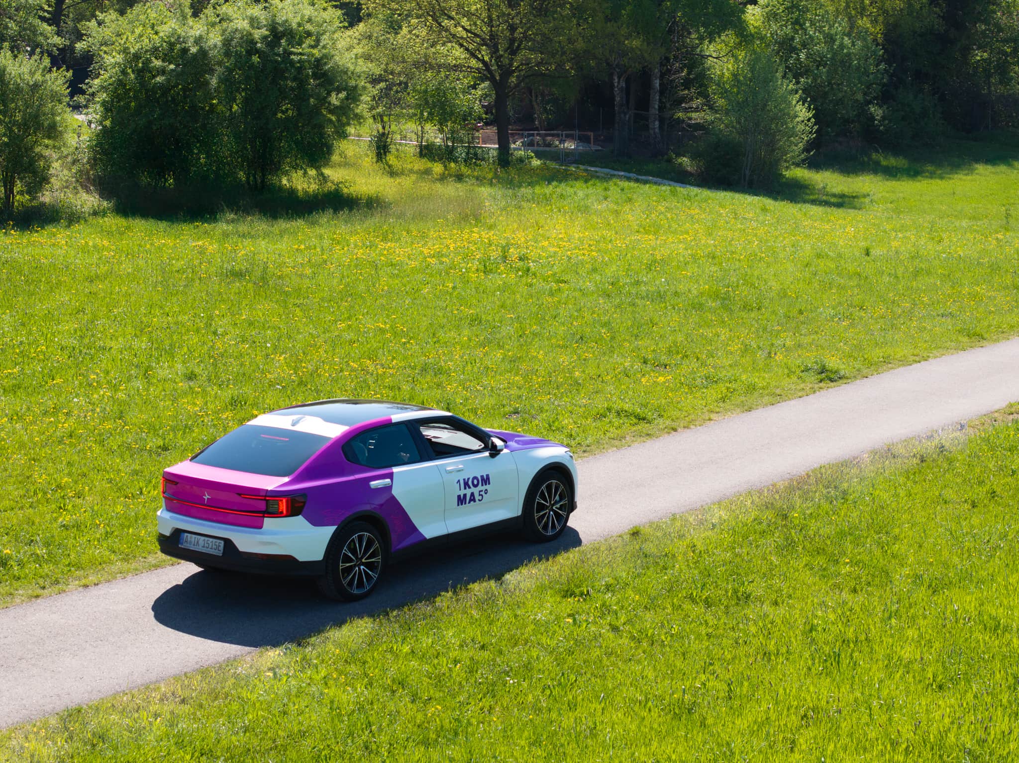 Ein Elektroauto von 1KOMMA5° fährt einen Feldweg entlang