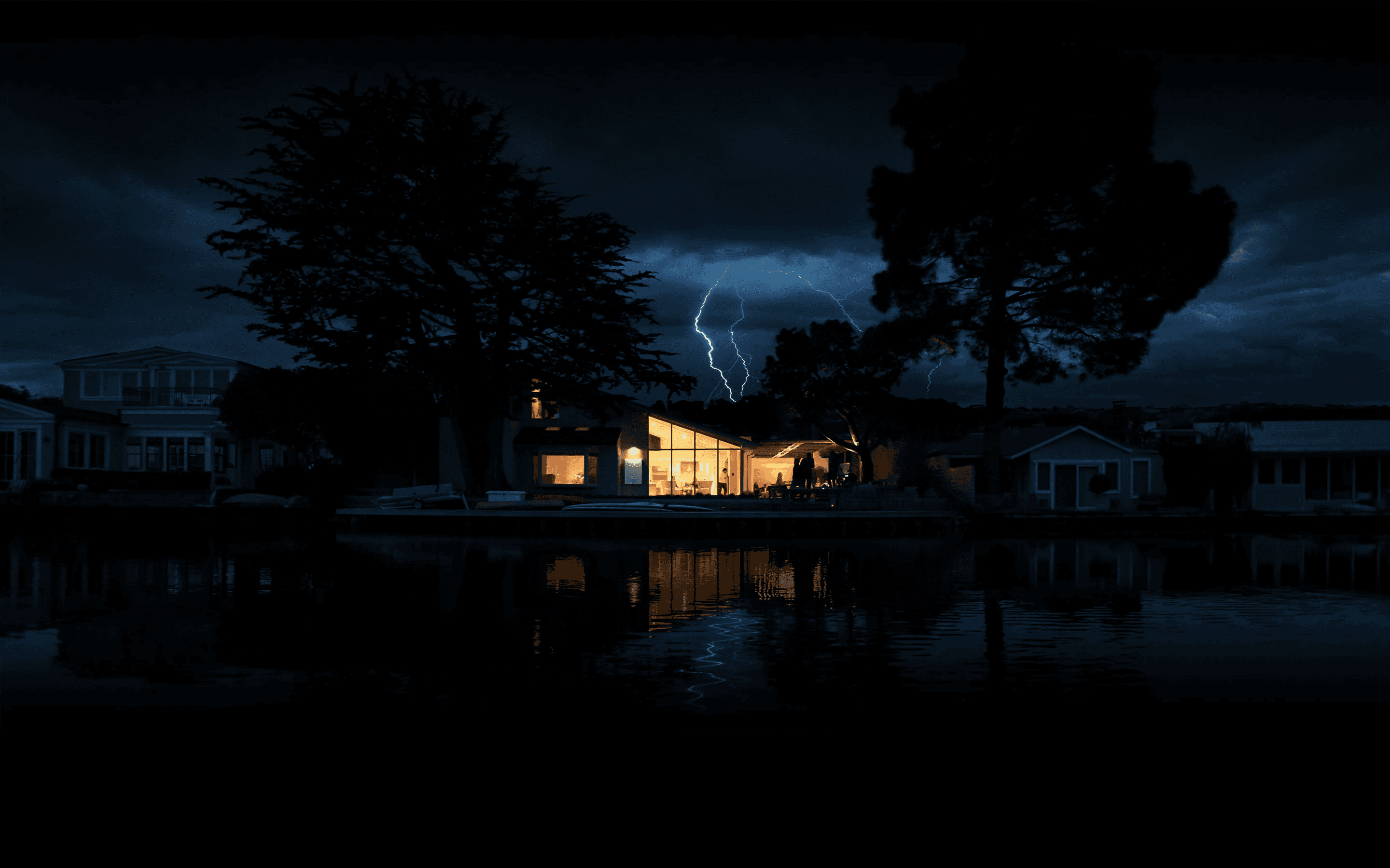 a modern house illuminated at night and blackout, framed by dark trees and a reflective water surface, with lightning striking in a stormy sky