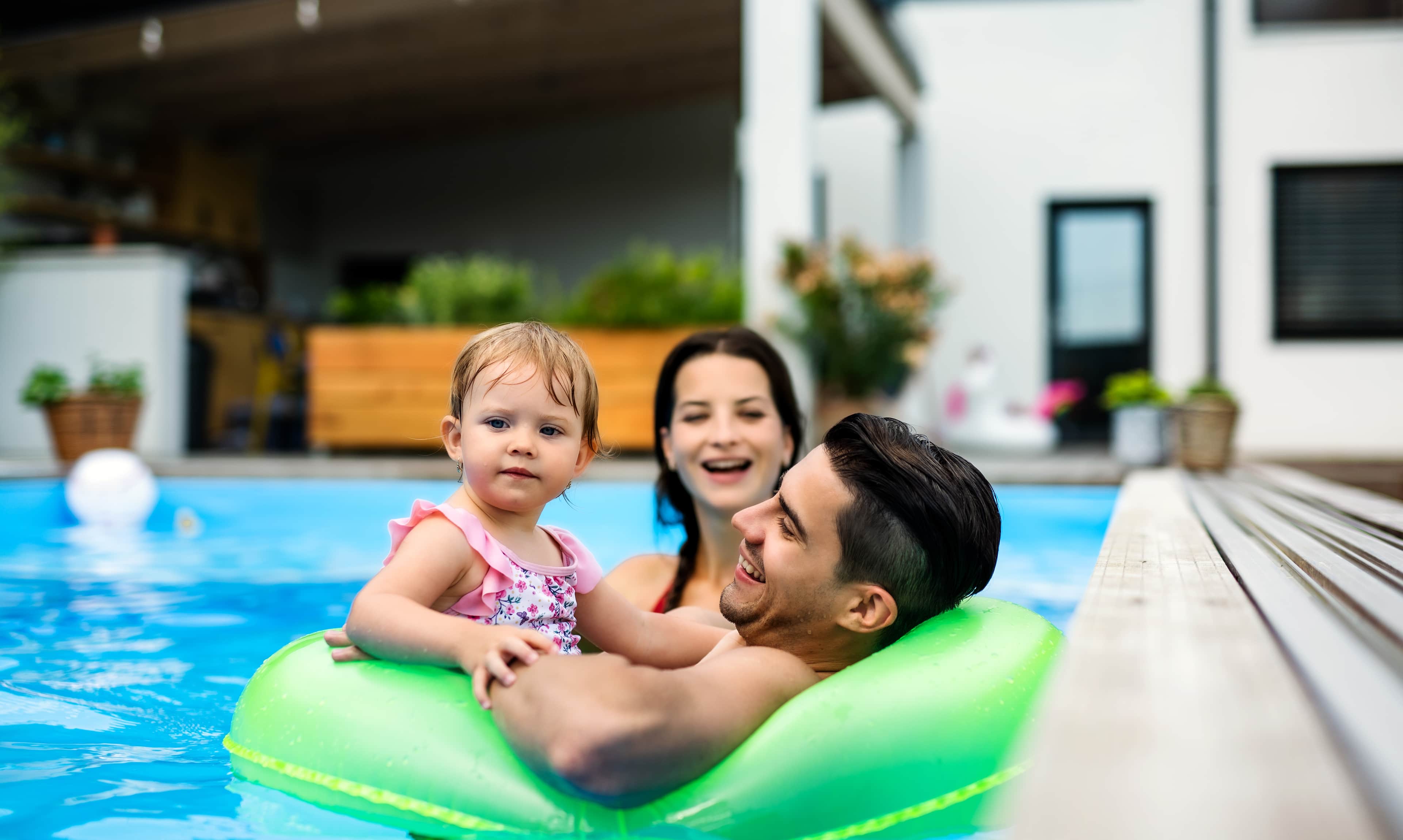 a family with a small baby having fun in a pool