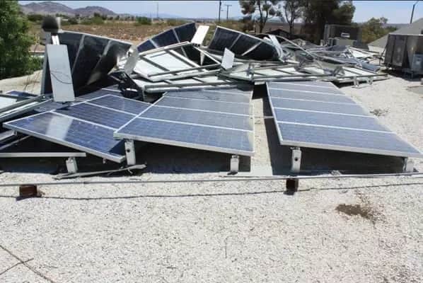 damaged solar panels scattered on a concrete roof