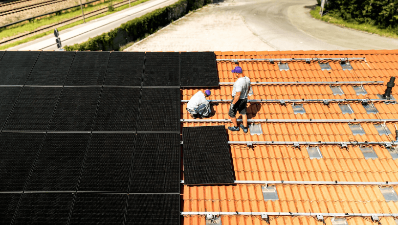 1KOMMA5° installers installing solar panels on a terracotta roof tile