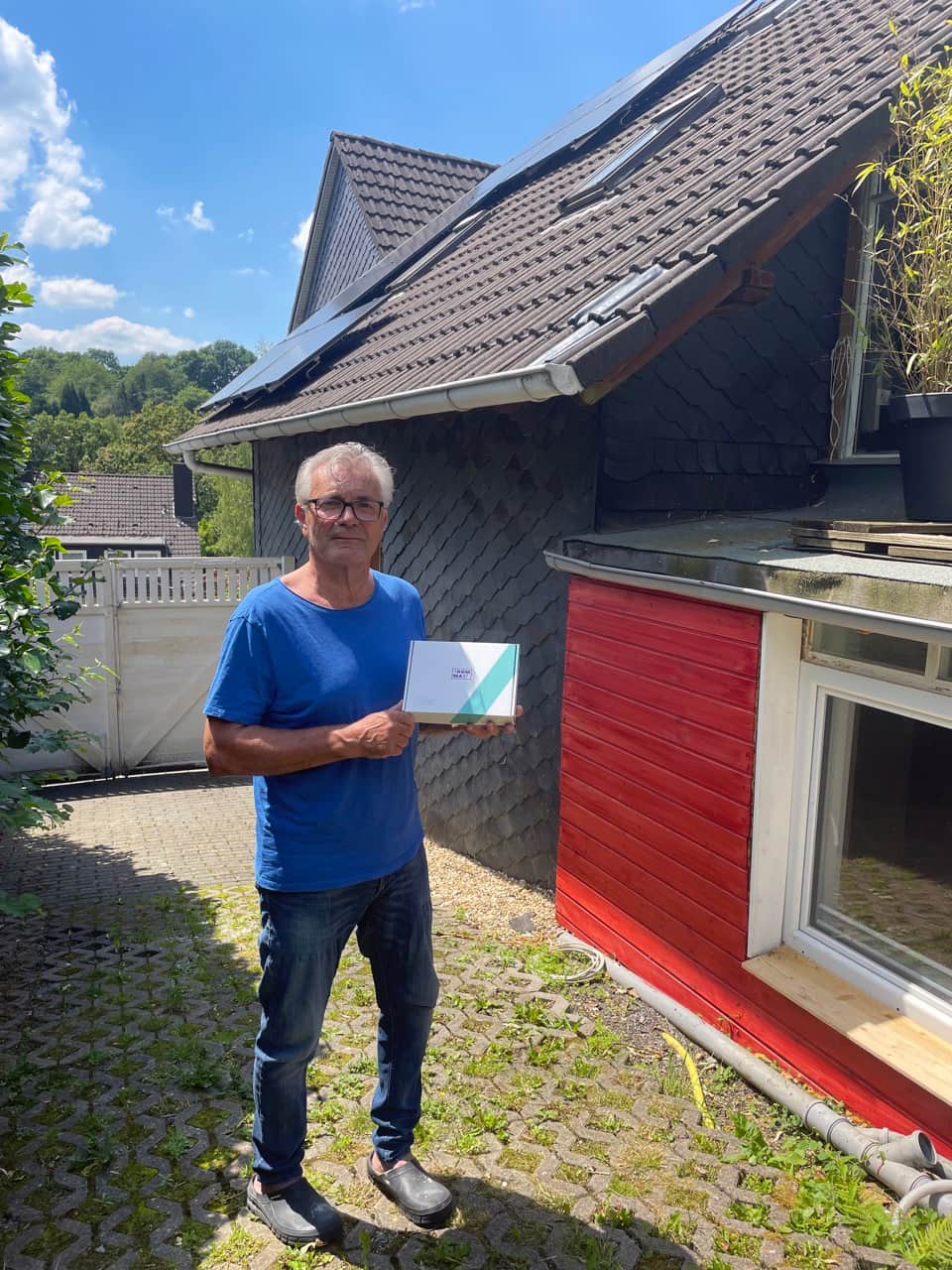 Zufriedener Kunde Zemke vor seinem Haus mit 1KOMMA5° Solaranlage.